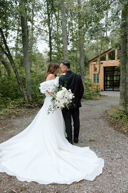 A couple walking toward the cottage through the woods